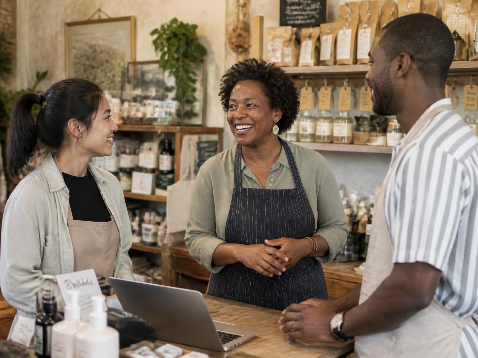 A small business owner talking with her team behind the counter of her shop
